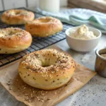 Freshly baked cottage cheese bagels with bread flour on a wire rack