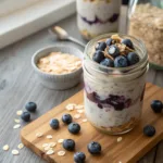 Blueberry overnight oats in a glass jar with almond milk