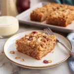 Moist oatmeal cake with coconut topping on a rustic plate