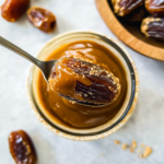 Homemade date caramel in a glass jar topped with a whole date