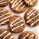 Freshly baked gingerbread latte cookies with crackled tops and a drizzle of creamy coffee icing arranged on parchment paper.
