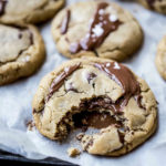 Soft Nutella cookies with a gooey melted center and a bite taken out.